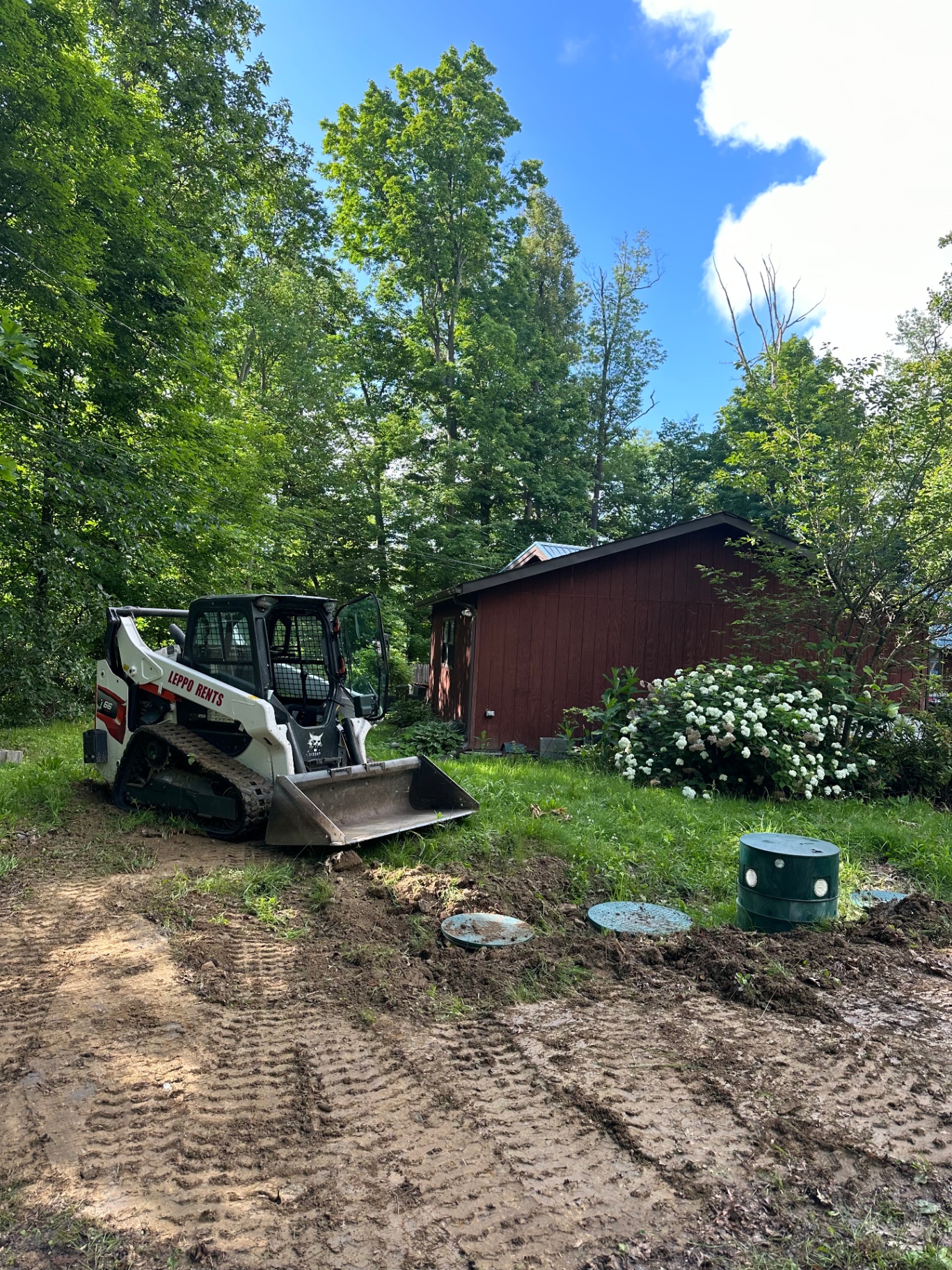 Compact track loader performing yard grading and drainage excavation at a Bath, Ohio residential property