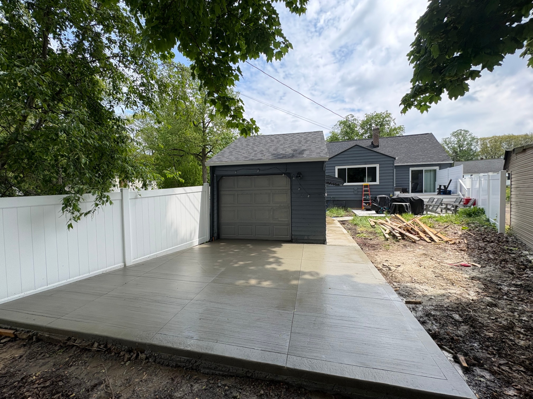 Freshly poured concrete driveway installation beside a detached garage in Norton, Ohio
