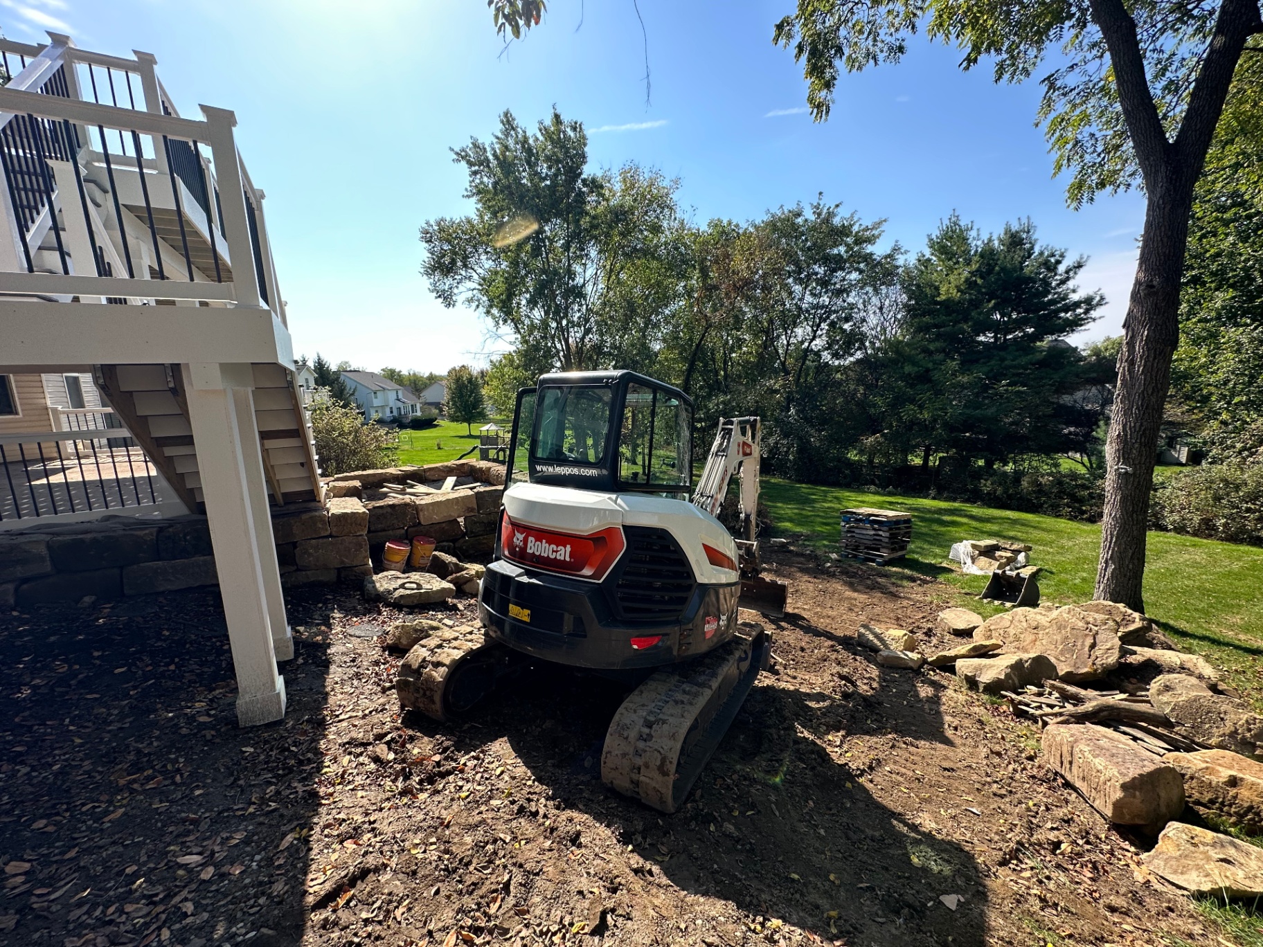 Backyard sitework and retaining wall excavation beneath a deck at a Richfield, Ohio property