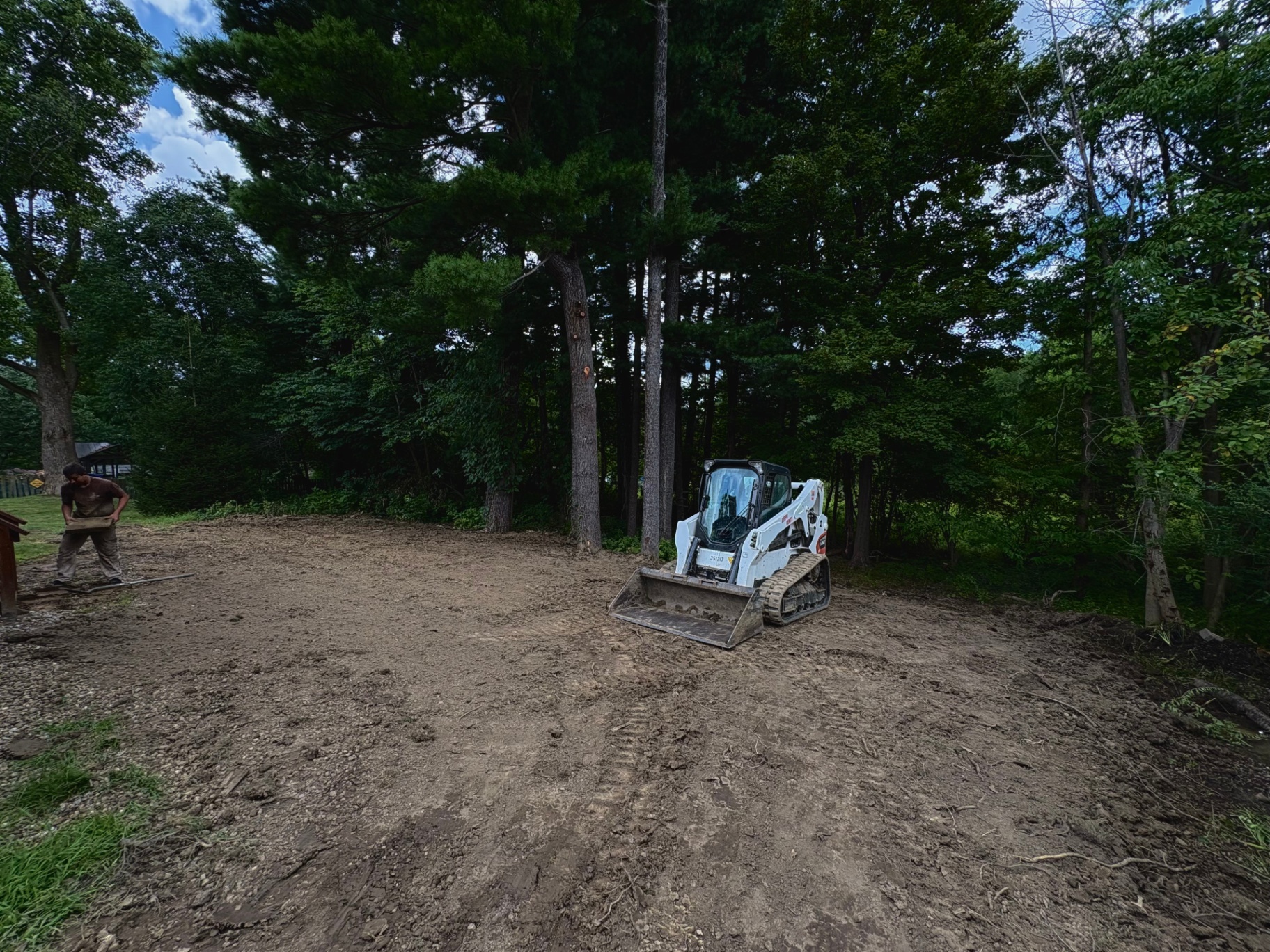 Bobcat compact track loader clearing and grading a wooded residential lot in Norton, Ohio